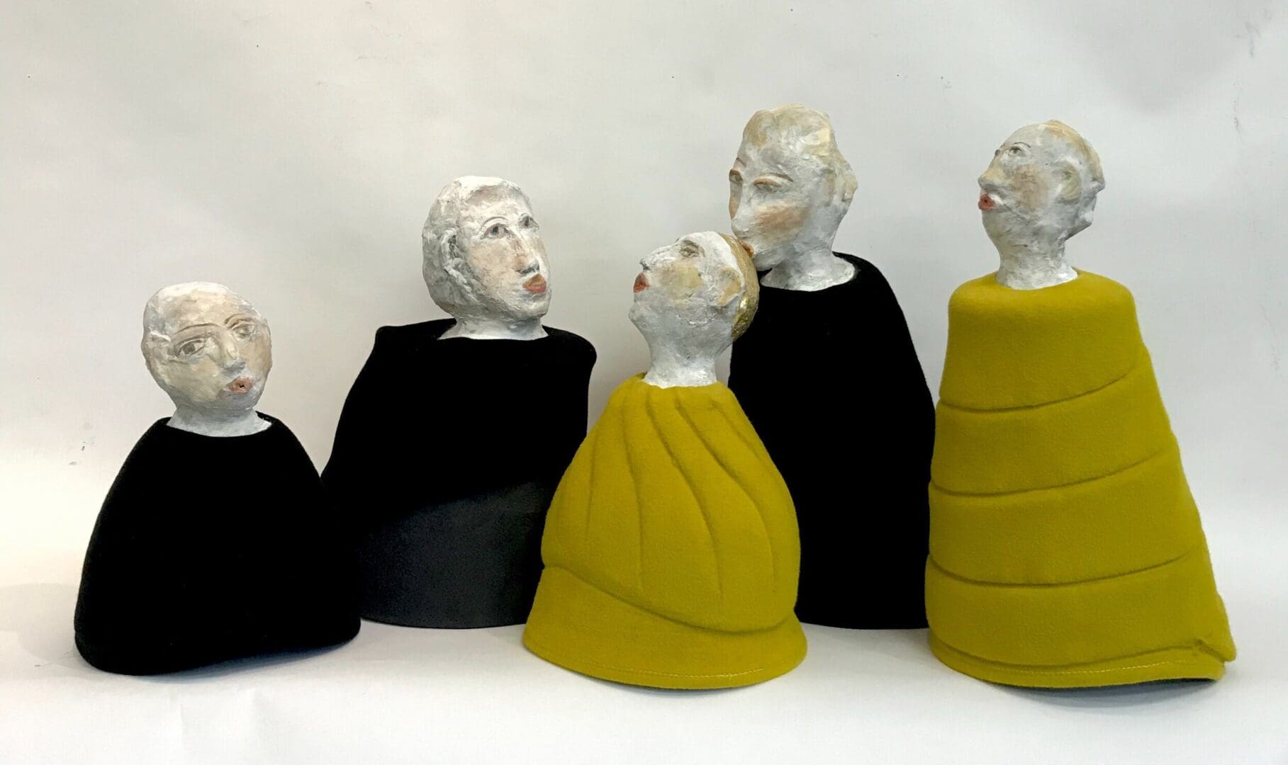 Five sculpted figures in conversation.
